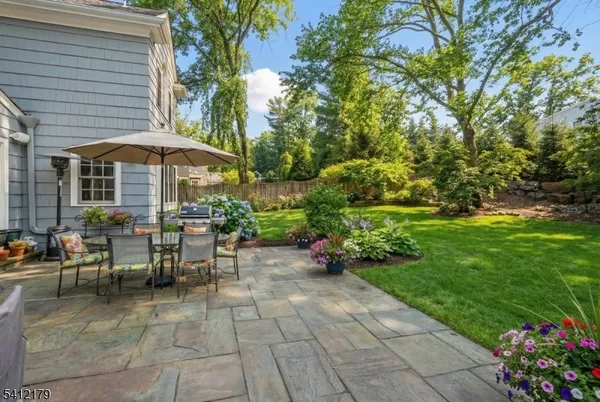 a view of a patio with table and chairs under an umbrella