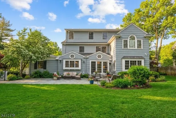 a front view of a house with a yard and trees