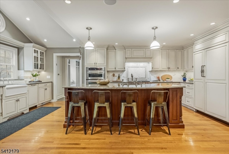 49 Hilltop Road Short Hills, NJ 07078 - Photo 5 of 34 a kitchen with stainless steel appliances granite countertop a dining table chairs refrigerator and cabinets