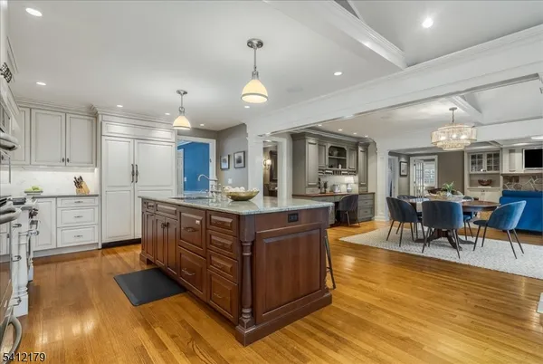 a kitchen with stainless steel appliances granite countertop a lot of cabinets and wooden floor