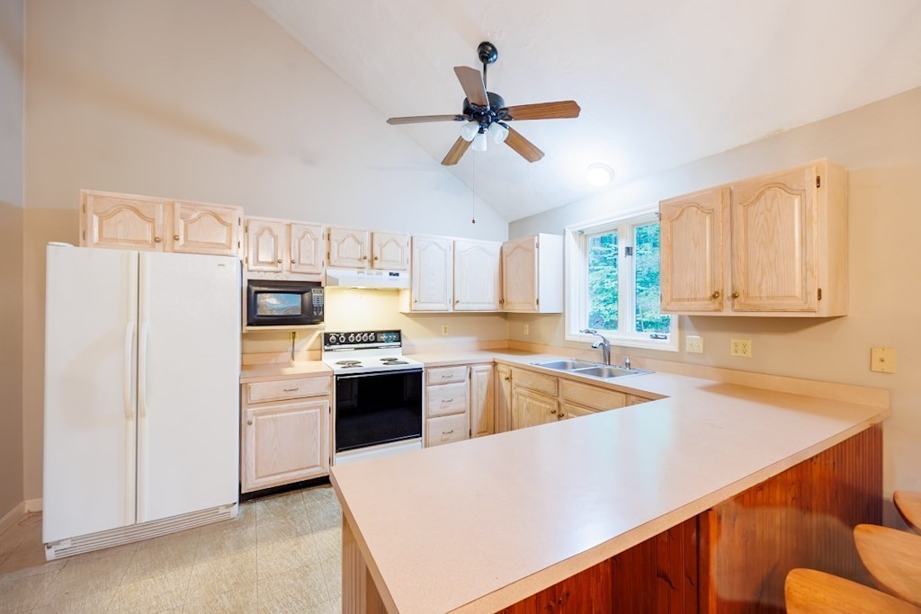 571 Douglas Road Northbridge, MA 01588 - Photo 6 of 29 a kitchen with a refrigerator a stove a sink and white cabinets