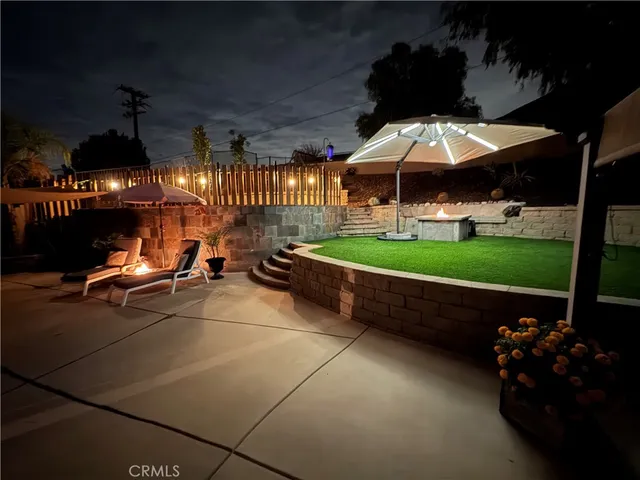 a view of a patio with table and chairs under an umbrella