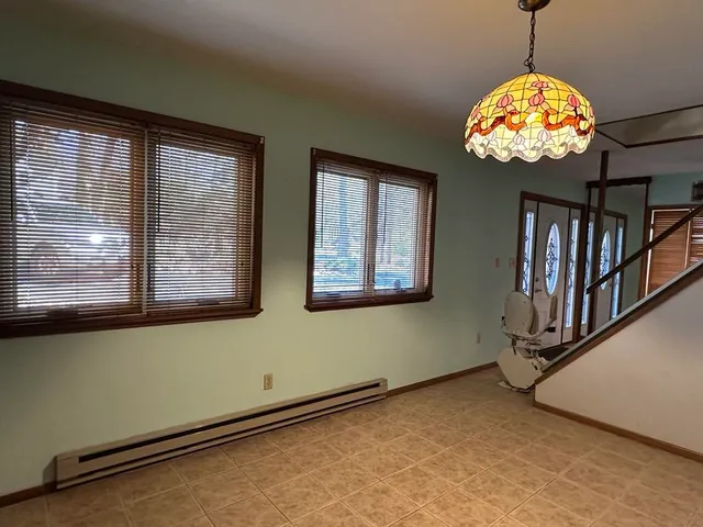 a view of an empty room with window and stairs
