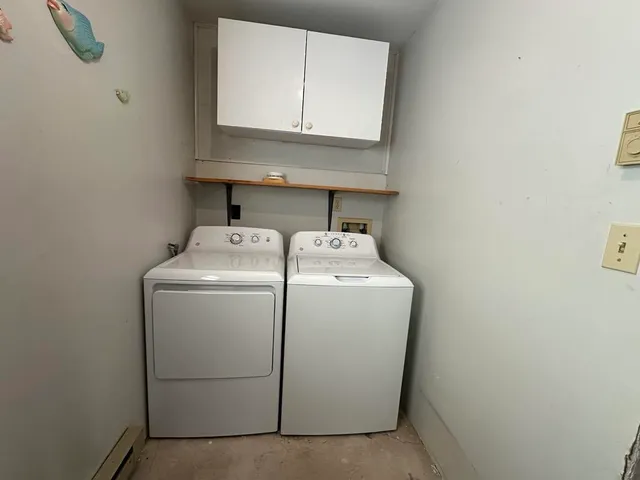 an empty room with a fireplace and cabinet