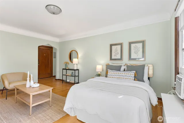 a bedroom with a bed a table and painting on the wall