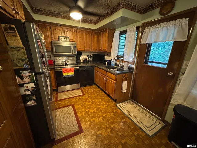 a kitchen with stainless steel appliances granite countertop sink refrigerator and microwave