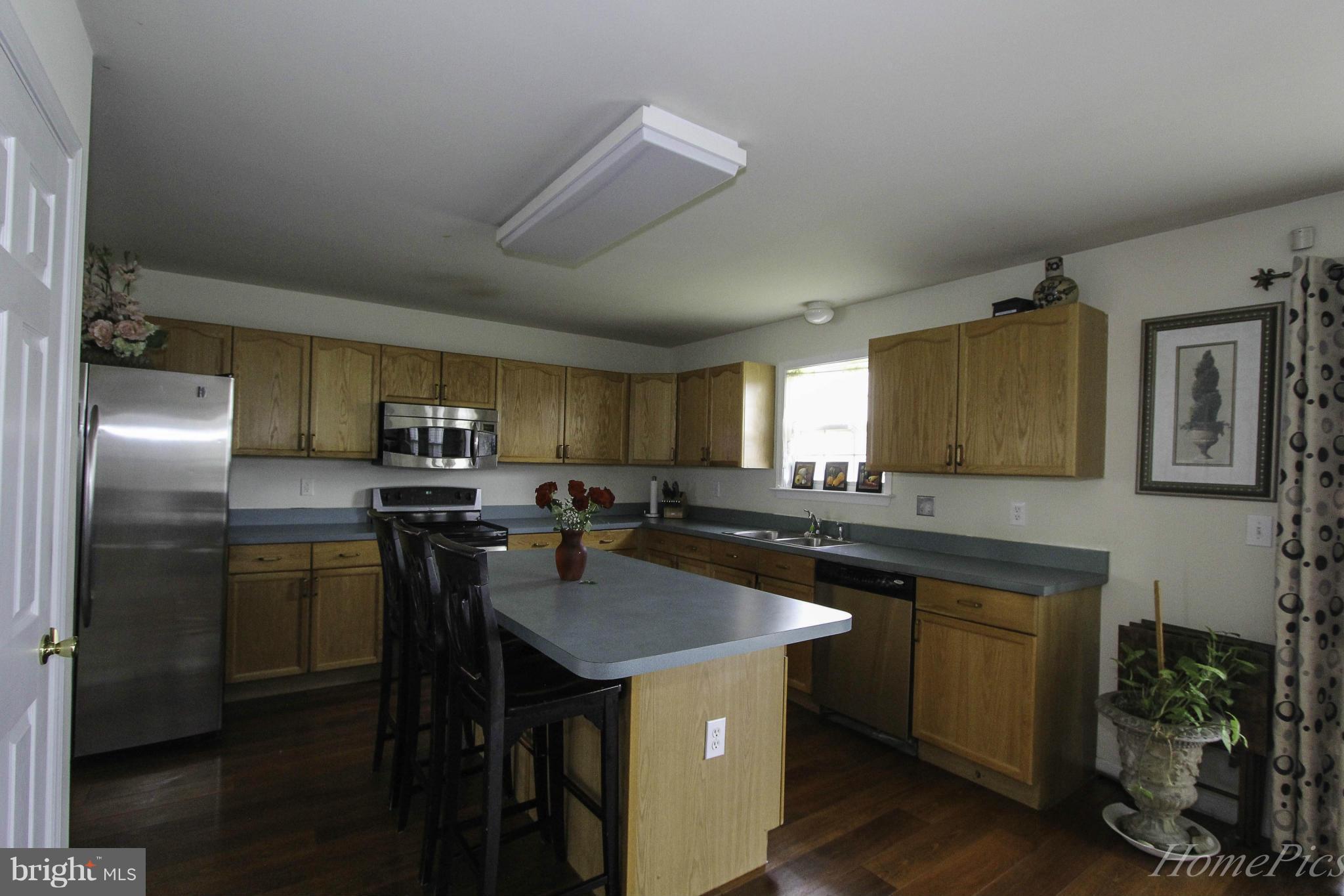 109 Limited Drive Ranson, WV 25438 - Photo 13 of 29 a kitchen with kitchen island a sink stove and refrigerator
