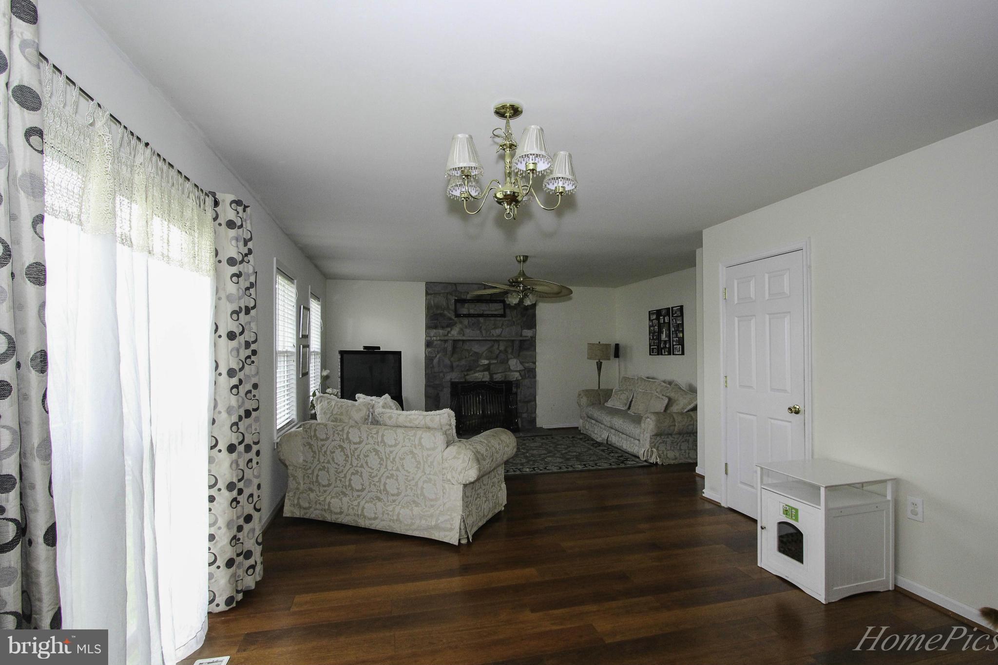109 Limited Drive Ranson, WV 25438 - Photo 10 of 29 a living room with furniture a fireplace and a chandelier
