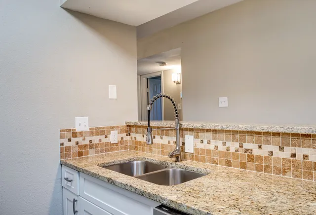 a kitchen with a sink and a view of living room