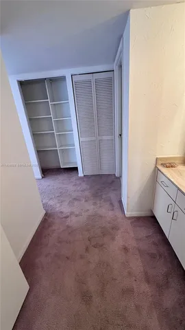 an empty room with a cabinet and mirrors