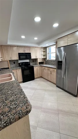 a large kitchen with a large counter top appliances and cabinets
