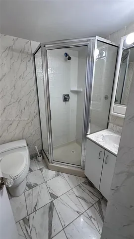 a bathroom with a granite countertop sink toilet and shower