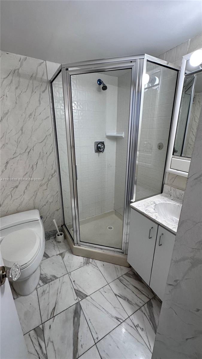 1865 Brickell Avenue, Unit A709 Miami, FL 33129 - Photo 10 of 19 a bathroom with a granite countertop sink toilet and shower