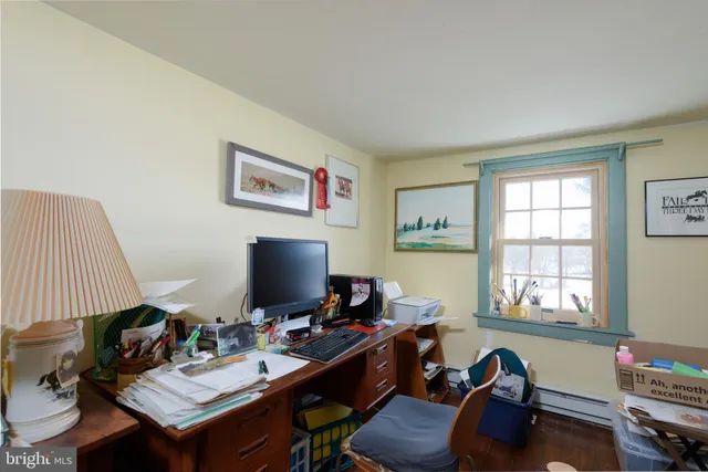 a view of a workspace with furniture and a window