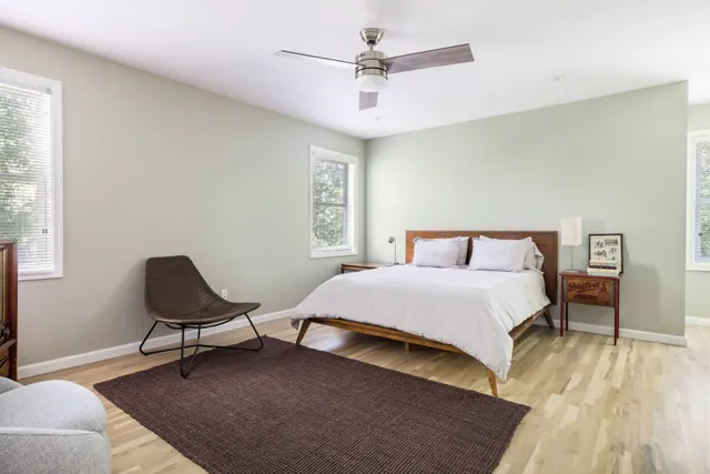 a bedroom with a bed window and chair