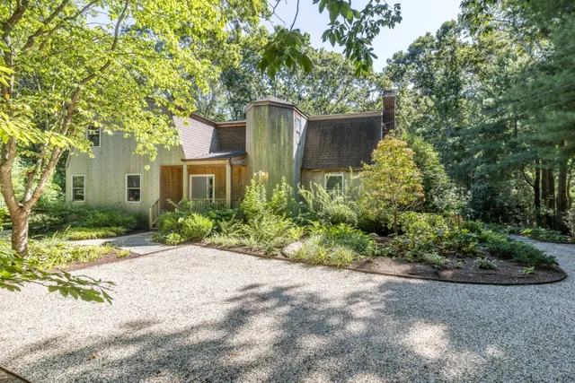 a front view of a house with a yard and potted plants