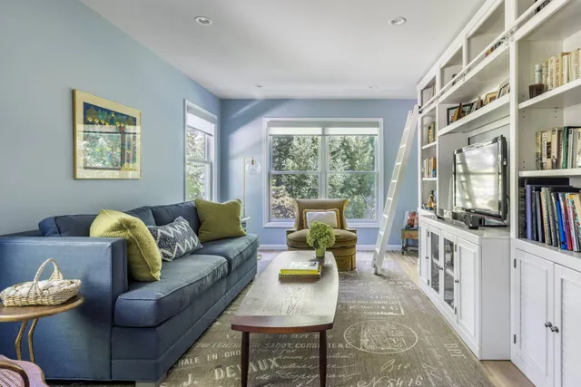 a living room with furniture and a book shelf