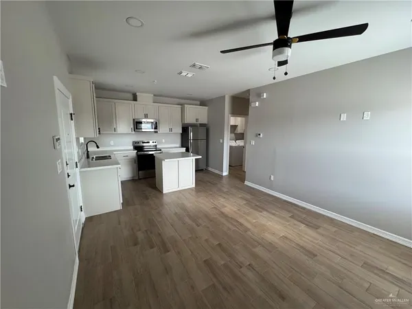 a kitchen with kitchen island a sink stainless steel appliances and cabinets