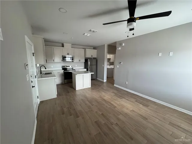 a kitchen with kitchen island a sink stainless steel appliances and cabinets