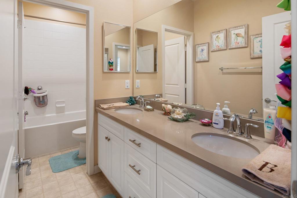 1158 Camino Prado Chula Vista, CA 91913 - Photo 18 of 25 a bathroom with a granite countertop sink and a mirror