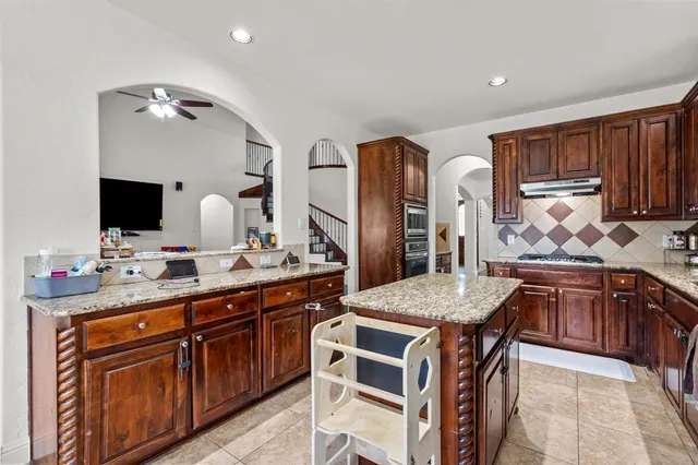 a kitchen with stainless steel appliances granite countertop a sink stove and cabinets
