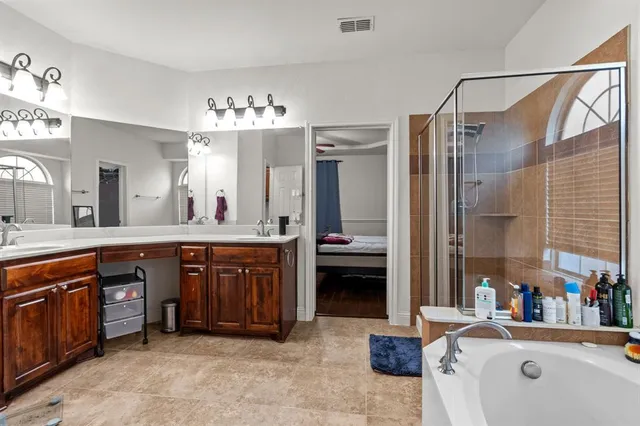 a bathroom with a tub a sink and a window