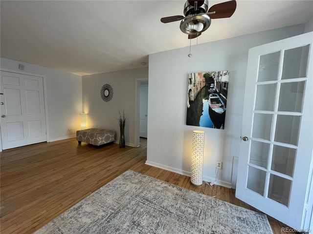 a view of a livingroom with wooden floor and a ceiling fan