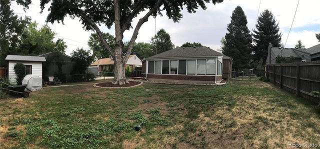 a view of a house with backyard and trees