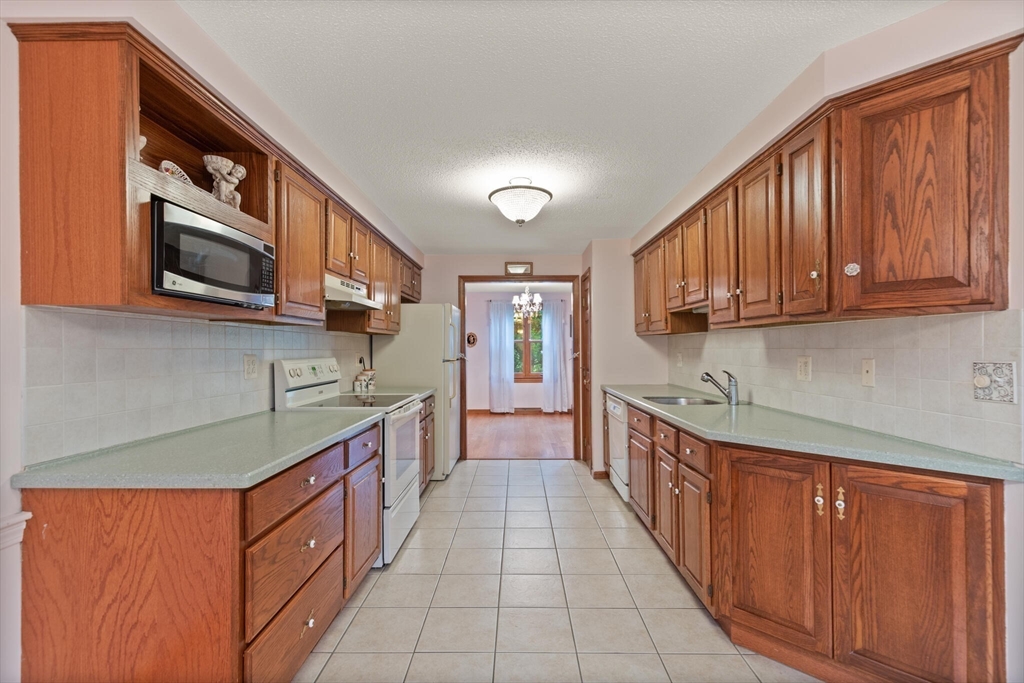 115 Village Post Road, Unit 115 Danvers, MA 01923 - Photo 11 of 36 a kitchen with stainless steel appliances granite countertop a stove and a sink