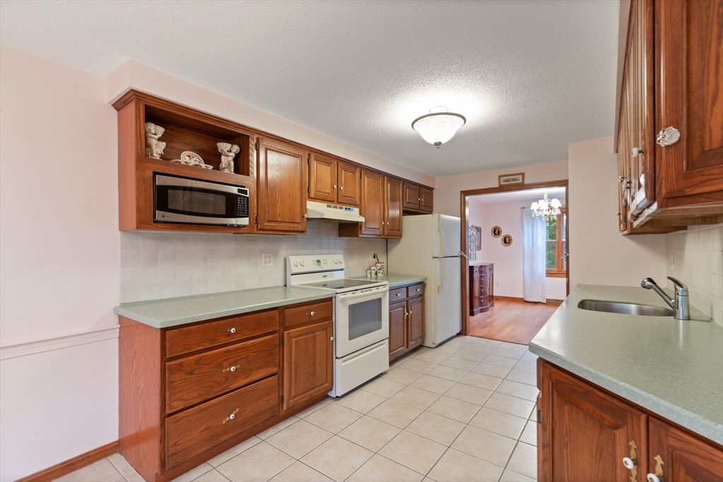 115 Village Post Road, Unit 115 Danvers, MA 01923 - Photo 12 of 36 a kitchen with stainless steel appliances granite countertop a stove and a sink