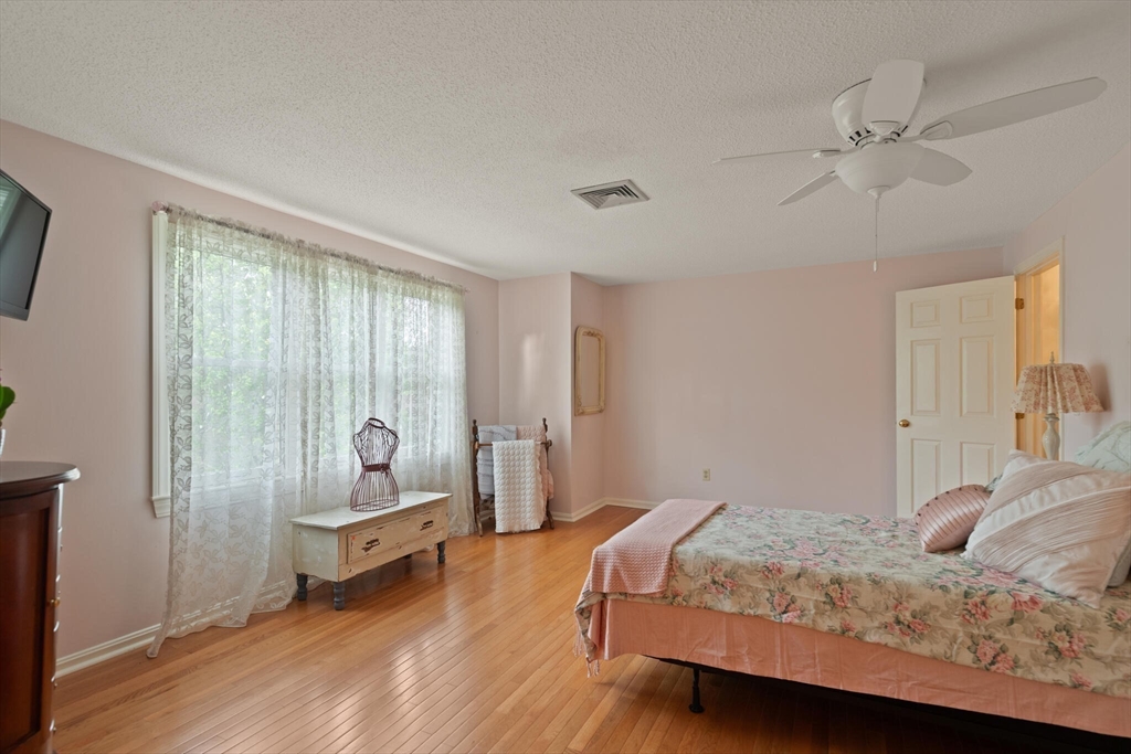115 Village Post Road, Unit 115 Danvers, MA 01923 - Photo 19 of 36 a bedroom with a bed and large windows