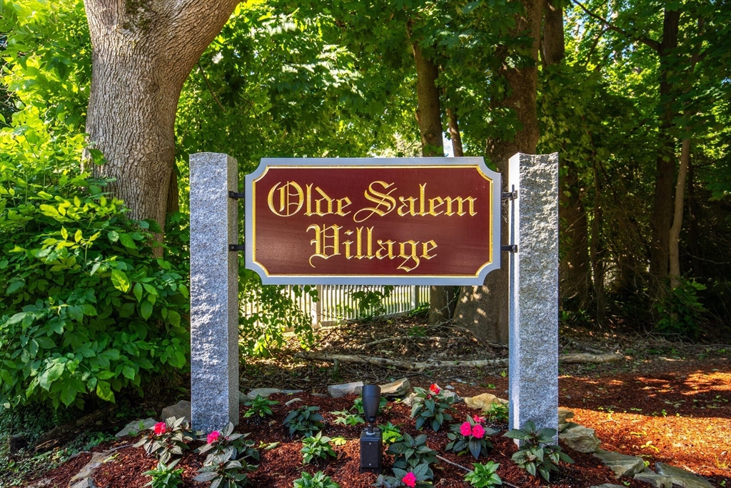 115 Village Post Road, Unit 115 Danvers, MA 01923 - Photo 2 of 36 a sign that is sitting on a brick wall