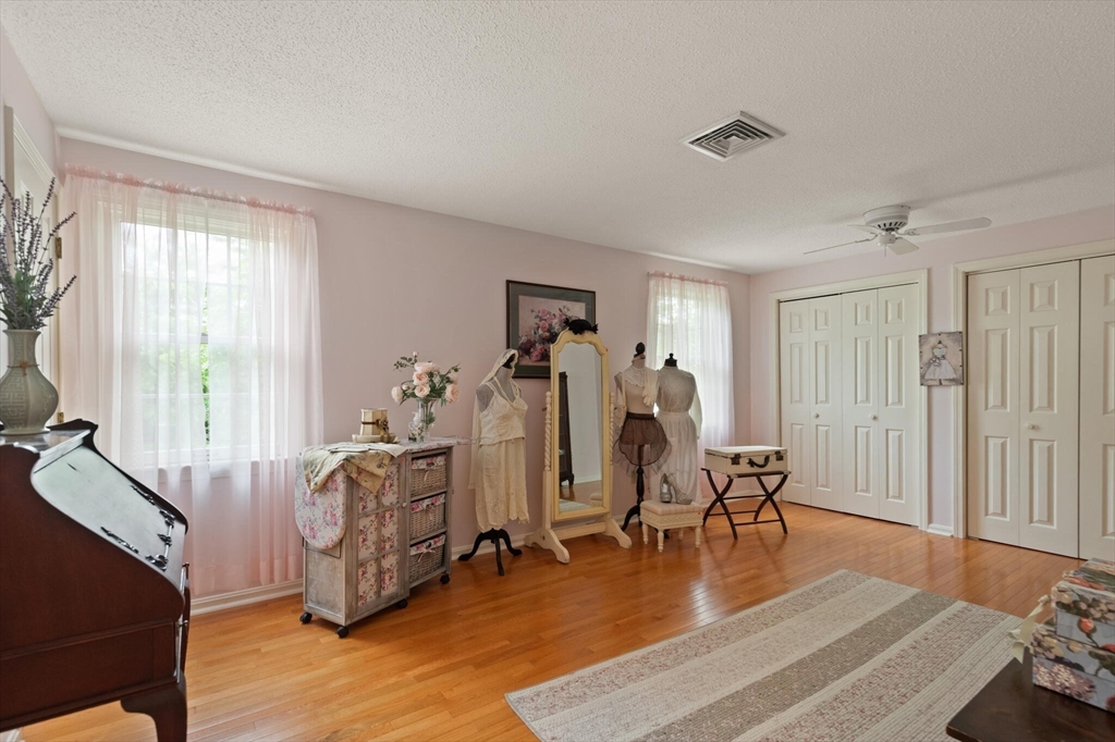 115 Village Post Road, Unit 115 Danvers, MA 01923 - Photo 22 of 36 a living room with furniture a wooden floor and gym equipment