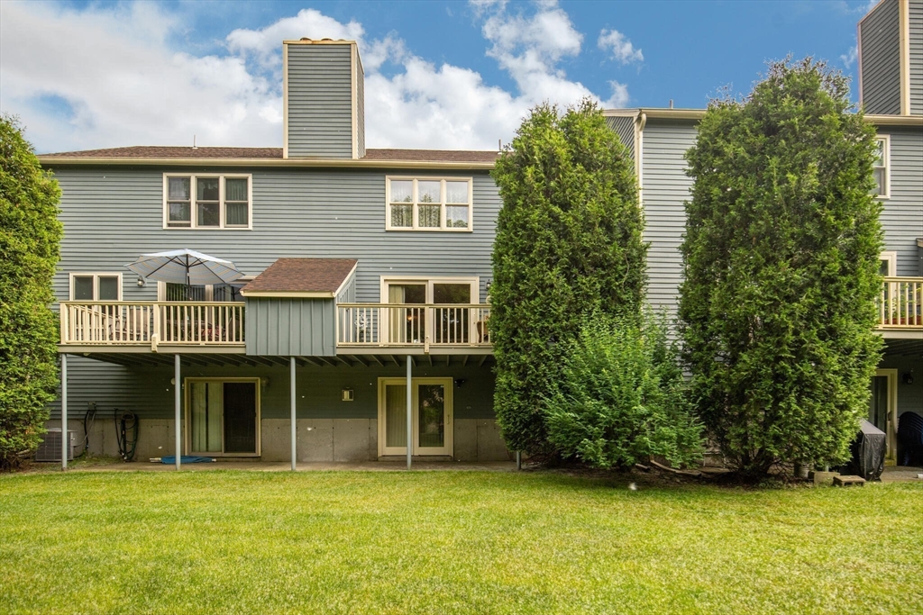 115 Village Post Road, Unit 115 Danvers, MA 01923 - Photo 27 of 36 a view of a brick house with a large windows and a yard