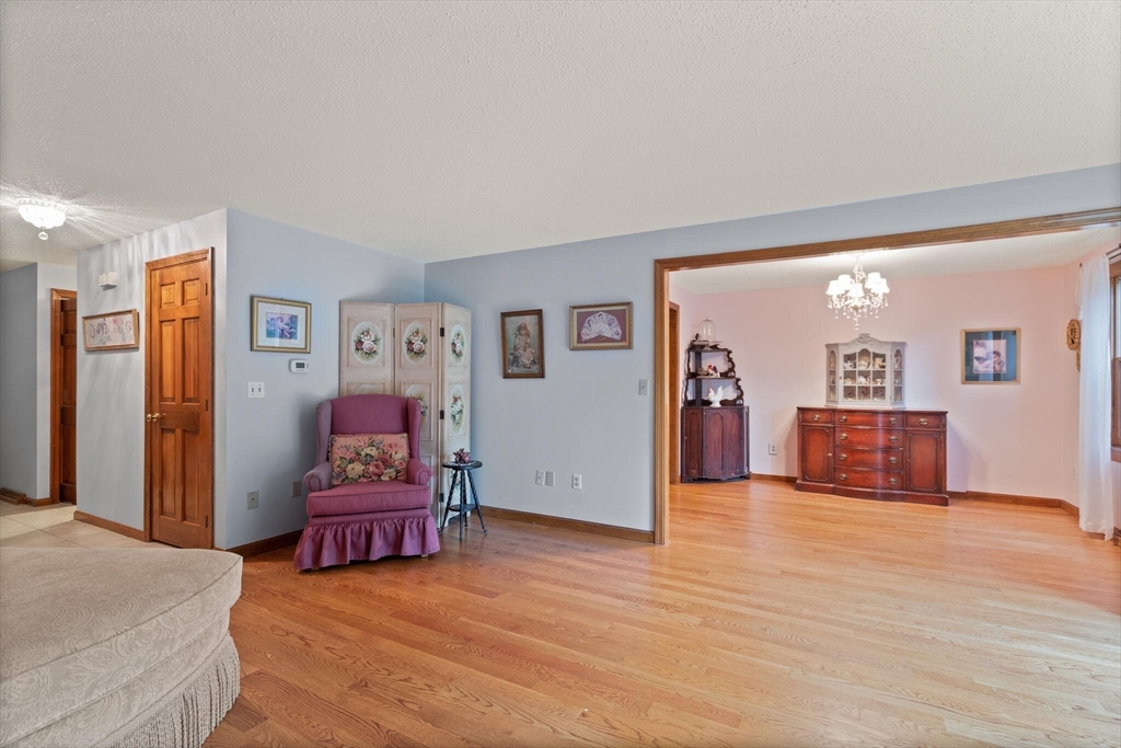115 Village Post Road, Unit 115 Danvers, MA 01923 - Photo 7 of 36 a view of a livingroom with wooden floor and cabinet