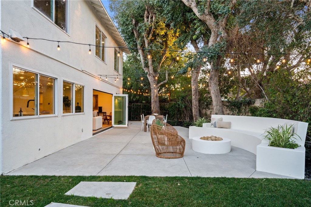 3383 Marigold Circle Costa Mesa, CA 92626 - Photo 37 of 43 a view of a white house with a chairs and table in a patio