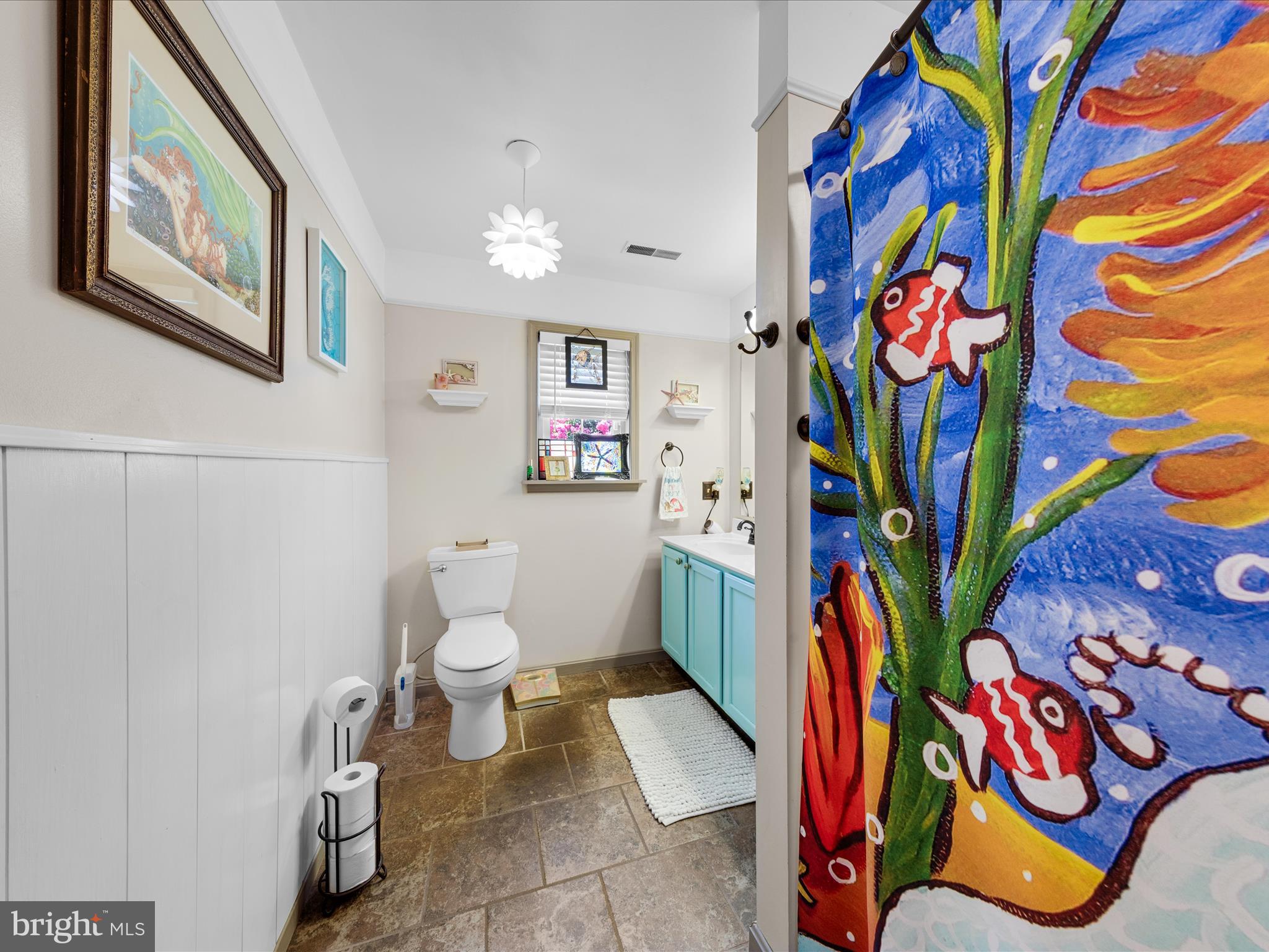 16869 West Randor Drive Milton, DE 19968 - Photo 42 of 76 a bathroom with a painting on the wall and a shower curtain