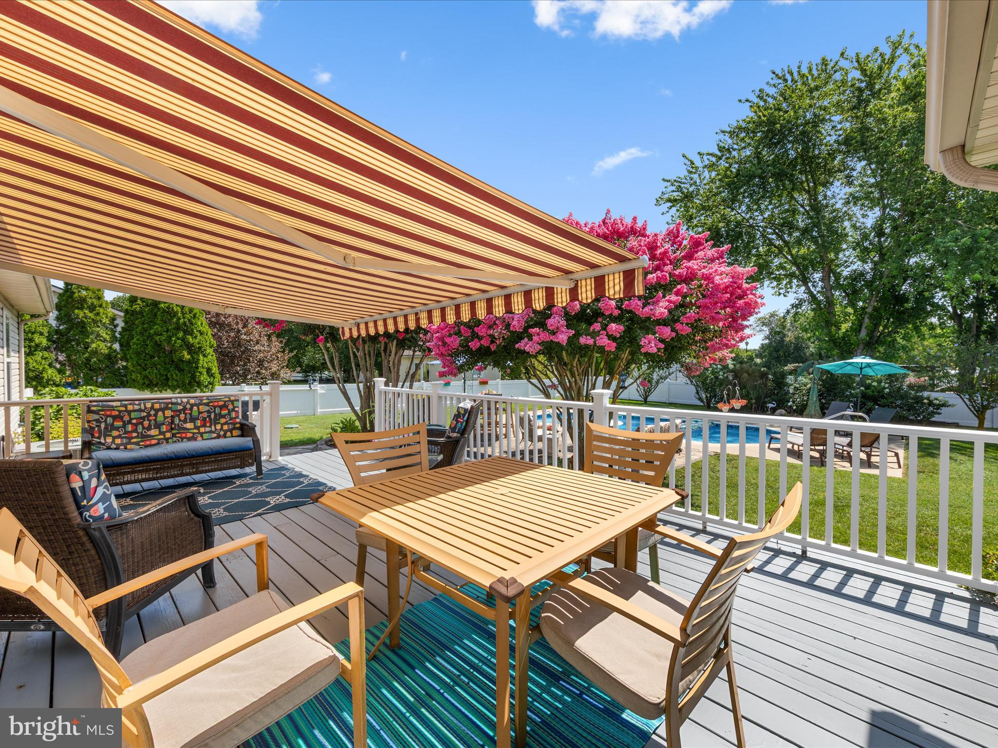16869 West Randor Drive Milton, DE 19968 - Photo 48 of 76 a view of a patio with couches table and chairs under an umbrella with a small yard