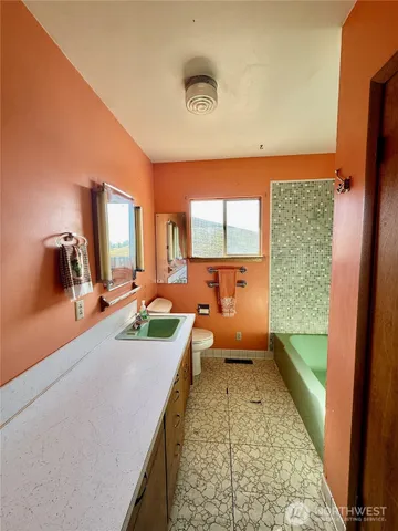 a bathroom with a tub sink and mirror