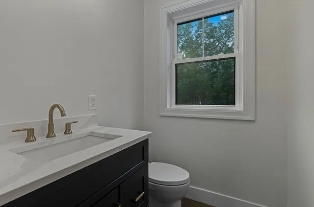 a bathroom with a sink a toilet and a window