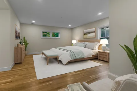 a bedroom with a large bed and a potted plant