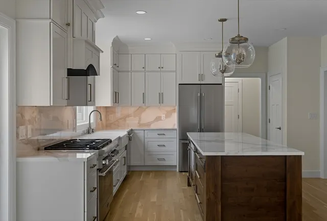 a kitchen with stainless steel appliances granite countertop a sink stove and refrigerator