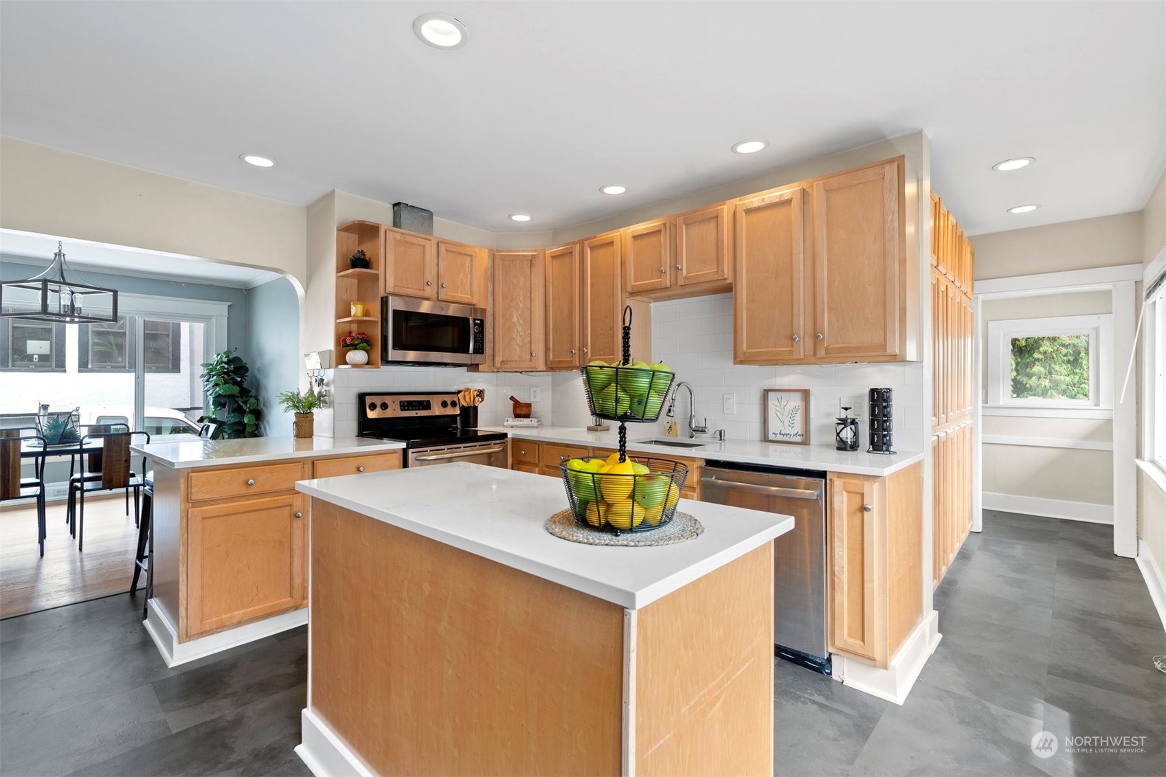 820 North 60th Street Seattle, WA 98103 - Photo 9 of 30 a kitchen with a stove a sink a microwave a dining table and chairs