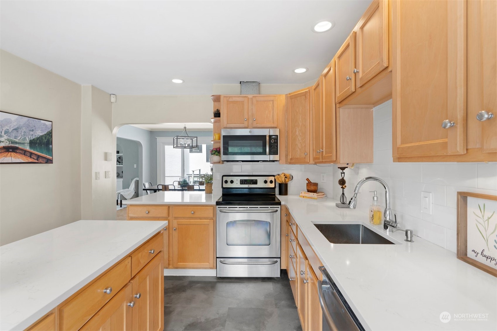 820 North 60th Street Seattle, WA 98103 - Photo 10 of 30 a kitchen with stainless steel appliances a stove sink microwave and cabinets