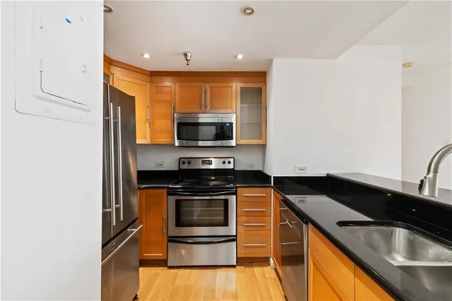 a kitchen with stainless steel appliances a sink a stove and microwave