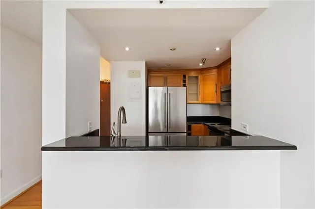 a kitchen with stainless steel appliances granite countertop a sink and a refrigerator