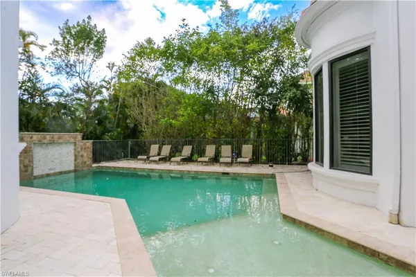 a view of a swimming pool with chairs in patio