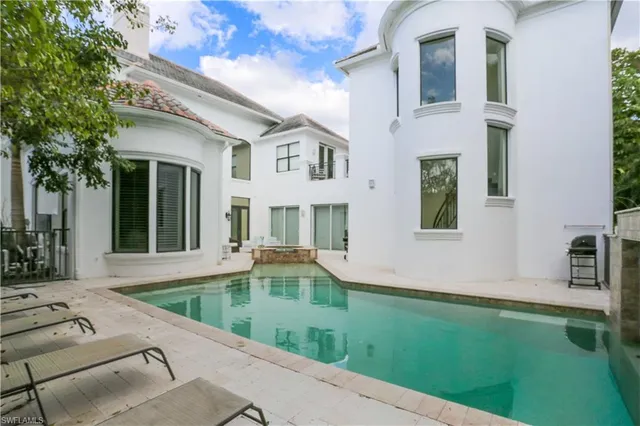 a house view with swimming pool and outdoor seating