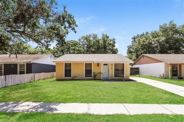 a front view of a house with a yard and trees