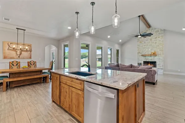 a kitchen with granite countertop a sink a counter top space and living room view